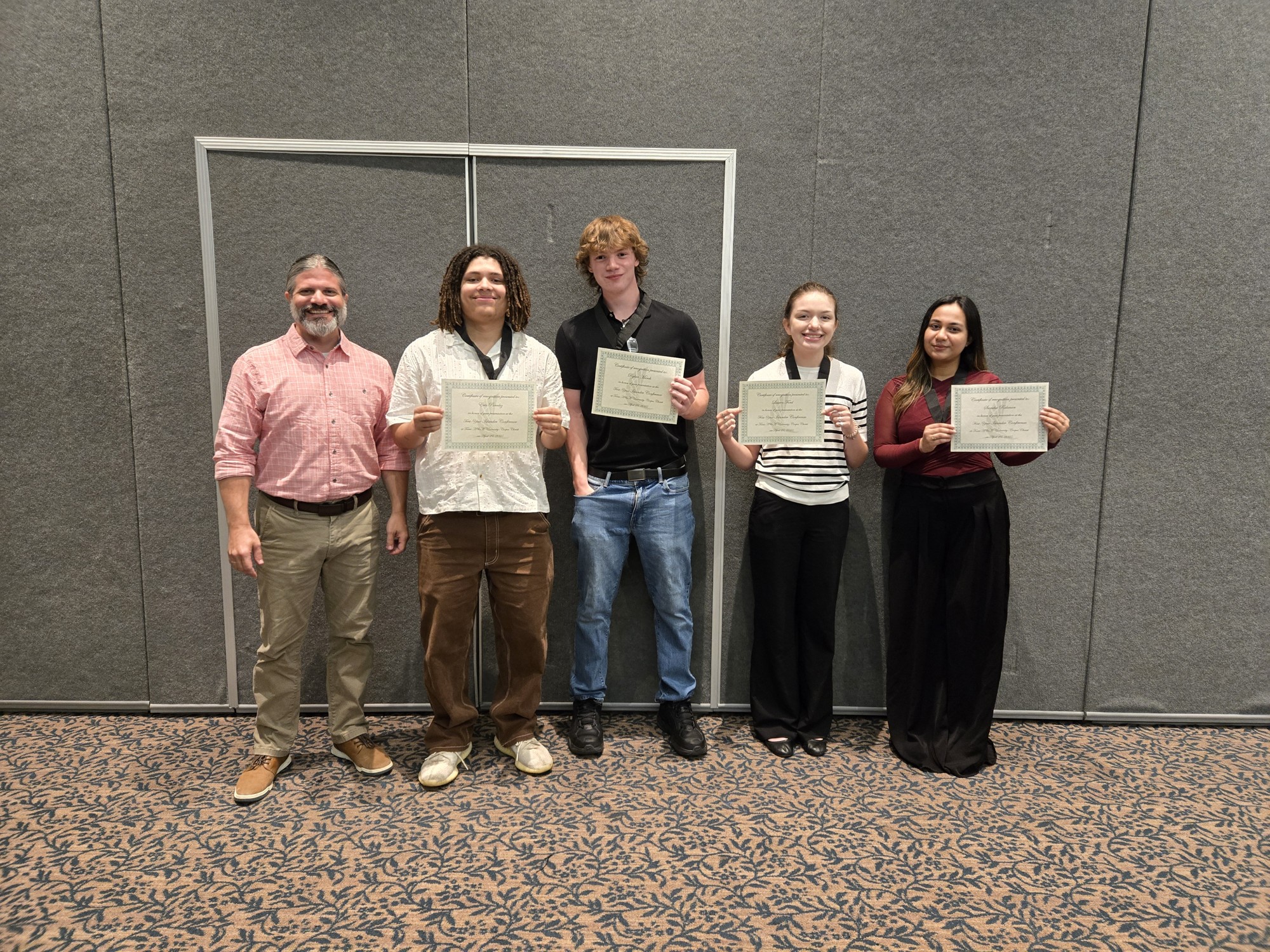 Capstone team holding presentation certificates at the First Year Islander Conference